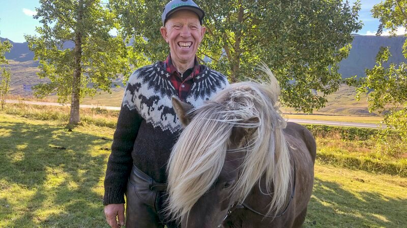 Ein Leben für die Pferde: Thórdur Júliússon, genannt Doddi, ist der wohl fröhlichste Isländer der gesamten Ostküste. Er züchtet schon sein gesamtes Leben Islandpferde und unterhält seine Reitgäste mit unzähligen Liedern und Sagen. Doddi lebt am Norðfjörður-Fjord, der aufgrund seiner Geschichte auch „Kommunistenfjord“ genannt wird. – Bild: NDR/​nonfictionplanet/​Annette Plomin