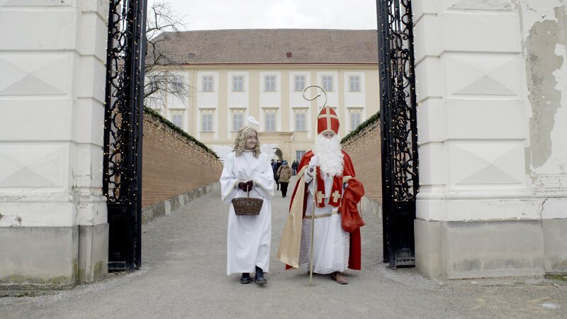 Der Nikolaus und ein Engel spazieren durch Schloss Hof. – Bild: ORF/​Produktion West/​Gerhard Mader