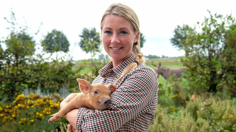 Gastgeberin Theresa Coßmann (28 J.) ist Agrarwirtin und kümmert sich um die Aufzucht der Schweine. – Bild: WDR/​Melanie Grande