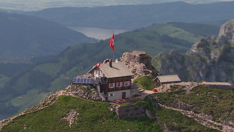 Hütte mit Flagge – Bild: ZDF und SRF. Hütte mit Flagge – Bild: ZDF und SRF.