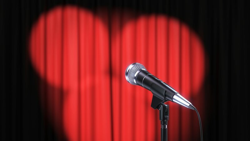 Red curtain with spotlights and microphone – Bild: Depositphotos /​ lexaarts