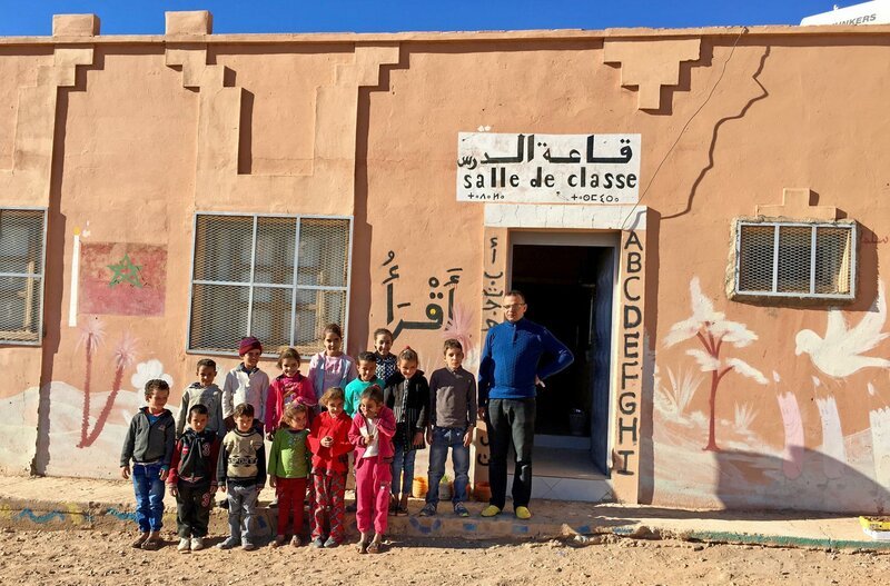 Schüler und Lehrer Lhoussine Oussisse vor der Wüstenschule. – Bild: ZDF und SWR/​Mouhcine El Ghomri.