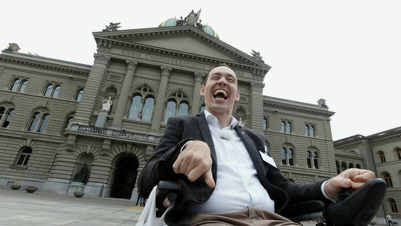SRF DOK: Handicap Behinderung: Das Märchen von der Inklusion Islam Alijajs ist sprech- und körperbehindert. Sein Traum und Fernziel ist ein Sitz im Nationalrat. SRF – Bild: SRF1 SRF DOK: Handicap Behinderung: Das Märchen von der Inklusion Islam Alijajs ist sprech- und körperbehindert. Sein Traum und Fernziel ist ein Sitz im Nationalrat. SRF – Bild: SRF1