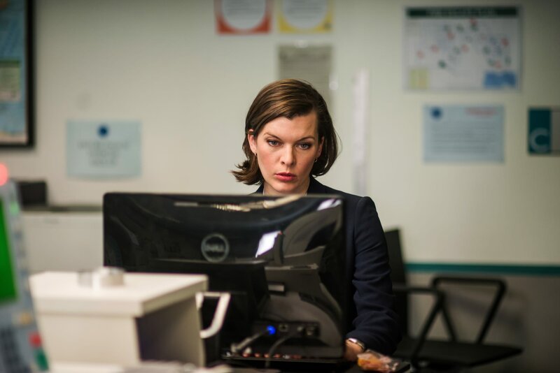 Kate (Milla Jovovich) spürt, dass irgendetwas an den Einreiseplänen von Dr. Balan merkwürdig ist, und möchte ihn deshalb genauer überprüfen. – Bild: ZDF und Nick Wall. Kate (Milla Jovovich) spürt, dass irgendetwas an den Einreiseplänen von Dr. Balan merkwürdig ist, und möchte ihn deshalb genauer überprüfen. – Bild: ZDF und Nick Wall.