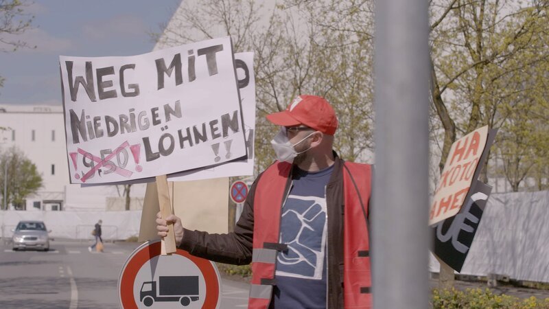 Ein Demonstrant fordert bessere Löhne für die Tönnies Mitarbeitenden. – Bild: ZDF und Ralf Huppke./​Ralf Huppke