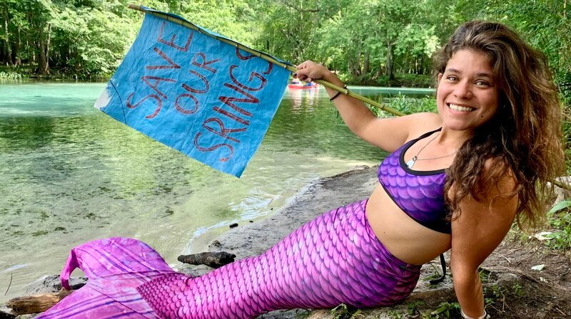 Michelle Colson liebt es, als Meerjungfrau in den glasklaren Lagunen Floridas zu schwimmen. Sie sind von Quellen gespeist. Als „Mermaid Michi“ kämpft Michelle inzwischen auf TikTok gegen die Ausbeutung des Lagunenwassers durch große Wasserabfüller. – Bild: NDR/​Anna Julia Leier