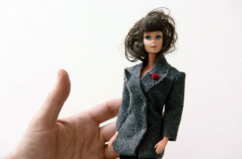 Martin Margiela zeigt eine Barbiepuppe mit YSL-Jackett, welches er für sie entworfen hat. – Bild: Reiner Holzemer Film /​ © Reiner Holzemer Film