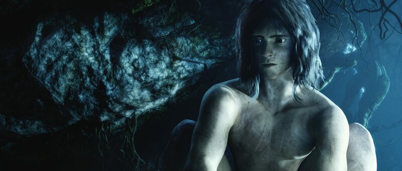 Vom Dschungel gezeichnet sitzt Tarzan nachdenklich in einer dunklen Höhle des Dschungels. – Bild: Constantin Film Lizenzbild frei