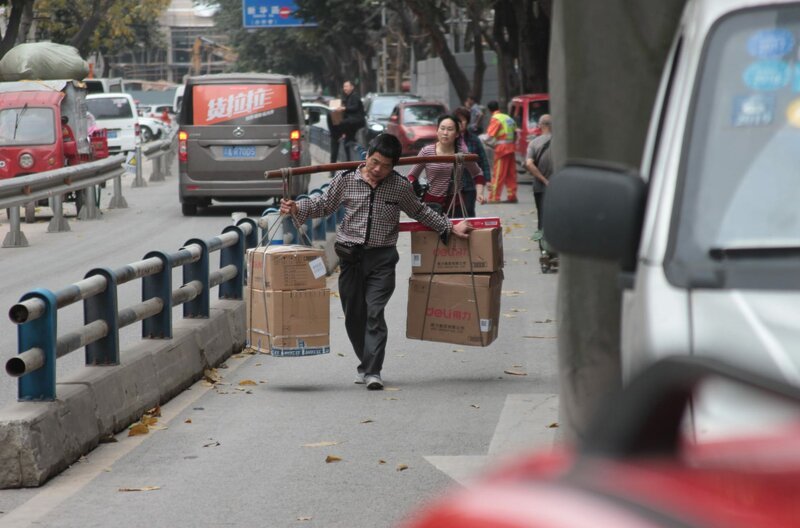 Typisch für Chongqing, Männer mit Bambus-Stab transportieren Lasten. – Bild: BR, phoenix, ARD Studio Peking /​ ARD Studio Peking/​BR/​phoenix