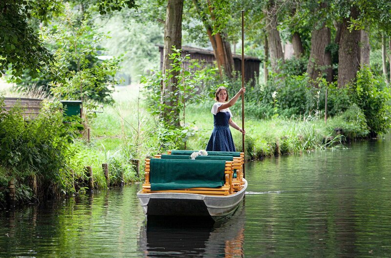 Anja lenkt den Kahn mit einer Rudel genannten Stange geschickt durch die Kanäle des Spreewalds. Ihren Gästen gibt sie einen Kurs darin, wie man das kleine Boot fährt. – Bild: ZDF /​ © Thomas Henk Henkel /​ © Thomas Henk Henkel