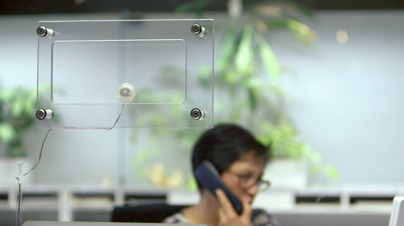 Seit einigen Monaten sitzt die Mitarbeiterin am Empfang des Bonner Rathauses hinter fingerdickem Glas. Ein Bürger hatte sie angegriffen und war sogar über die Theke gesprungen. Für die Stadt ein Grund, zu handeln. – Bild: BR/​rbb/​Saschko Frey