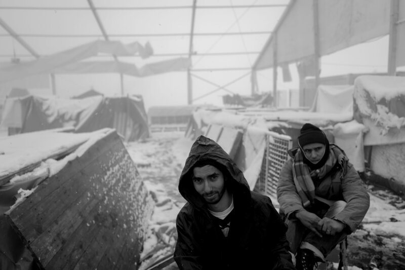 Flüchtlinge an einer Feuerstelle im abgebrannten IOM-Camp Lipa im Winter. – Bild: Kristof Huf /​ Kristof Huf /​ Kristof Huf/​Kristof Huf