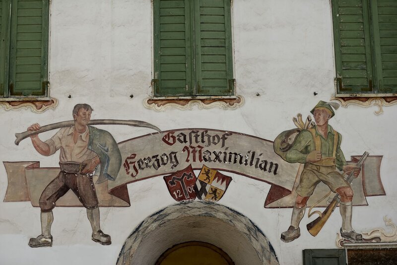 Lüftlmalerei am Gasthof Herzog Maximilian über dem Eingang, Gmund am Tegernsee. – Bild: BR/​Bernhard Graf