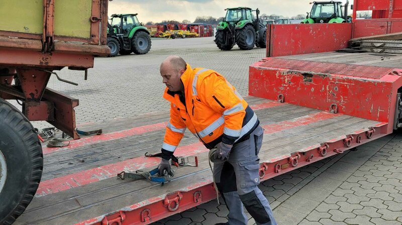 Brummi-Fahrer Arne Marhenke beim Sichern seiner Ladung. Er ist jeden Tag auf den Höfen im Nordwesten unterwegs, um gebrauchte Landmaschinen abzuliefern oder aufzuladen. – Bild: NDR/​video:arthouse