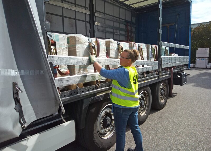 Die Verstrebungen der Seitenwände müssen bei jedem Ladevorgang entfernt und wieder angebracht werden. Schwerstarbeit für die Truckerin. – Bild: SWR Die Verstrebungen der Seitenwände müssen bei jedem Ladevorgang entfernt und wieder angebracht werden. Schwerstarbeit für die Truckerin. – Bild: SWR