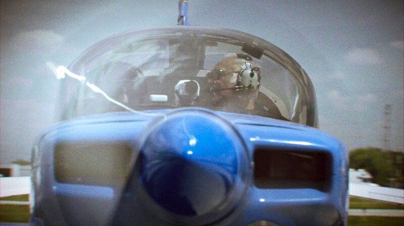 Greg Stinis, Skywriter in 2. Generation, kurz vor dem Start. Er konnte ein Flugzeug vor einem Auto steuern. – Bild: MDR/​Conrad Lobst/​Filmakademie Baden-Württemberg