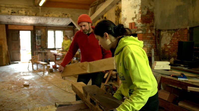 Ausbilder Wido Hahne zeigt den Mädchen von der Jugendbauhütte, wie man ein altes Fachwerkhaus denkmalgerecht saniert. – Bild: NDR