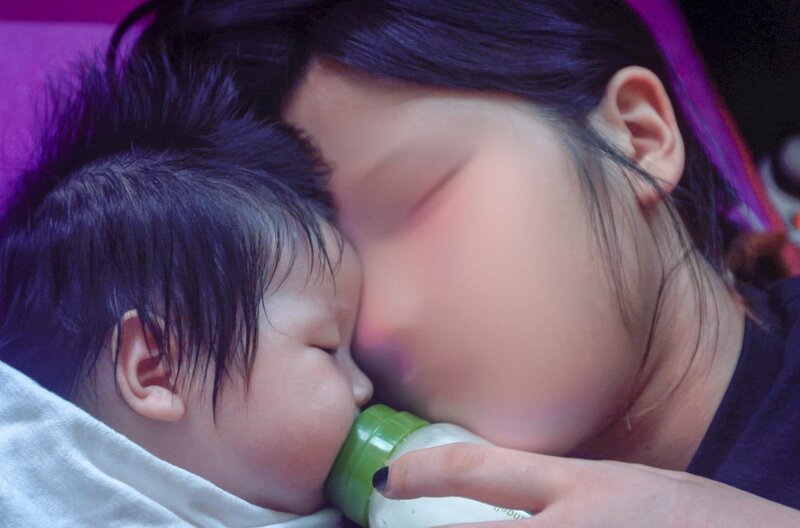 Eine junge Mutter ruht sich aus, während sie ihr schlafendes Baby mit Hilfe einer Milchflasche stillt. – Bild: SWR/​Sun Hee Engelstoft /​ © SWR/​Sun Hee Engelstoft