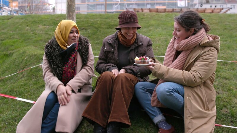 Gesundheitswissenschaftlerin und Mitgründerin Eva Weirich (3.v.r.) feiert mit einem Stück Kuchen die langersehnte Eröffnung des Gesundheitszentrums Neukölln. Ihr Projekt ist nicht profit-, sondern gemeinwohlorientiert. – Bild: ZDF und Kristof Kannegießer./​Kristof Kannegießer