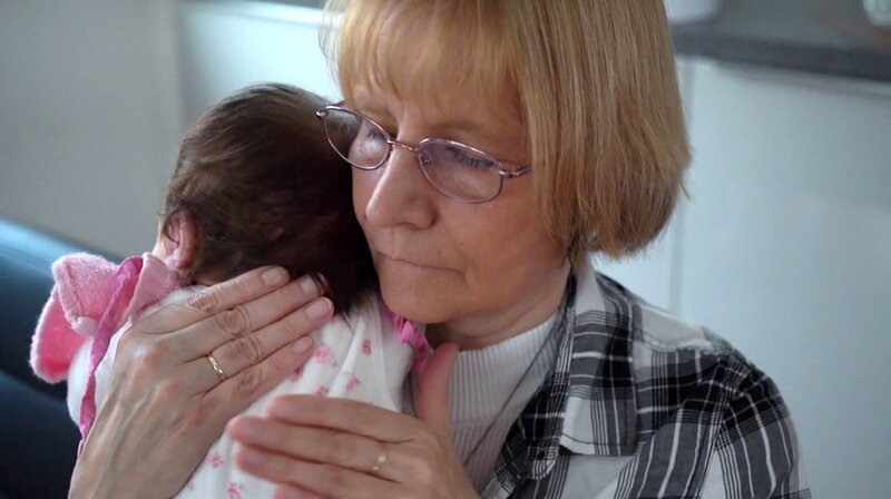 Immer liegt ein Baby in der Wiege von Elke Baumann. Als Kurzzeitpflegerin kümmert sie sich um Säuglinge, deren Zukunft ungewiss ist und die ihr vom Jugendamt in Obhut gegeben werden. 87 Babys hat Krisenmutter Elke Baumann aus Marzahn-Hellersdorf schon betreut. Für eine begrenzte Zeit schenkt sie den Kindern Liebe und Aufmerksamkeit. – Elke Baumann kümmert sich seit dem Mauerfall, also seit über 30 Jahren um Babys, die vom Jugendamt in Obhut genommen wurden. – Bild: BR/​rbb