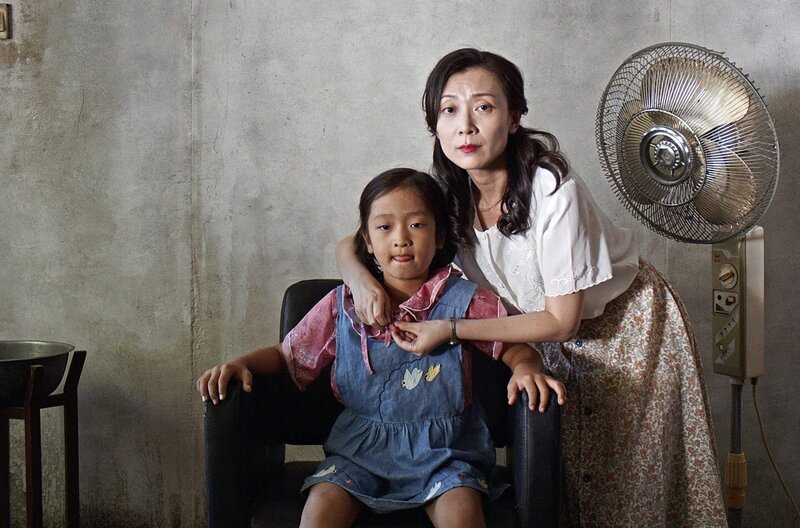 Die Mutter (Jiali Wang) hat den siebenjährigen Yan (Bowen Hu) als Mädchen verkleidet, bevor der Beamte für Bevölkerungsplanung eintrifft. – Bild: arte