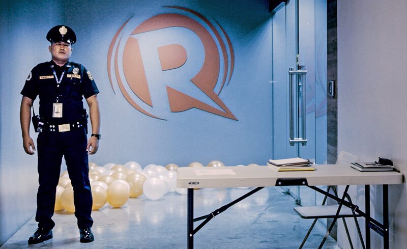Der Eingang zum Büro von Rappler. Ein Polizist bewacht das Gebäude. – Bild: phoenix/​SWR