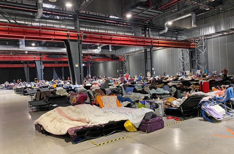 Messehalle in Warschau, allein einer Halle müssen 1000 Menschen auf Liegen schlafen und hoffen, dass sie irgendwie weiterkommen. – Bild: WDR/​Isabel Schayani