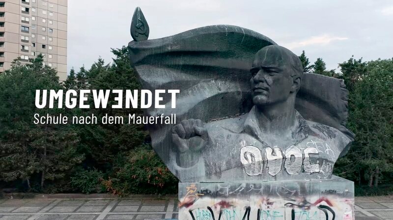 In den Schulen der DDR war die sozialistische Staatsideologie über vier Jahrzehnte tiefverwurzelt. Lehrer*innen fungierten im DDR-Schulsystem nicht nur als Wissensvermittler, sondern oft auch als verlängerter Arm der SED. Als die Mauer im November 1989 fällt, zerbricht auch der sozialistische Mikrokosmos Schule über Nacht. – Thälmann-Denkmal mit Grafik. – Bild: mdr/rbb In den Schulen der DDR war die sozialistische Staatsideologie über vier Jahrzehnte tiefverwurzelt. Lehrer*innen fungierten im DDR-Schulsystem nicht nur als Wissensvermittler, sondern oft auch als verlängerter Arm der SED. Als die Mauer im November 1989 fällt, zerbricht auch der sozialistische Mikrokosmos Schule über Nacht. – Thälmann-Denkmal mit Grafik. – Bild: mdr/rbb