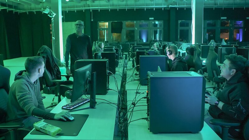 In der Eventhalle eines Hamburger Gaming-Hotels findet eine Trainingssession in einem Videospiel statt. Angeleitet werden sie durch ihren Game-Trainer Ron Manjang (2.v.l.). – Bild: ZDF und Andrzej Król.