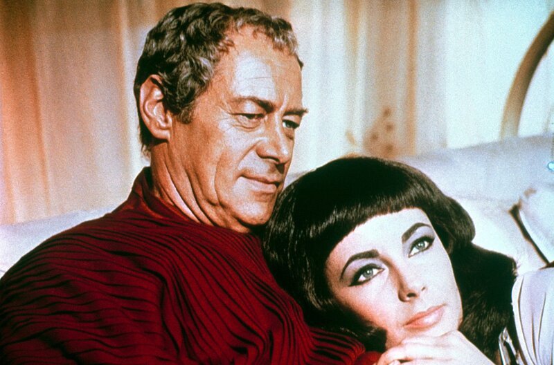 Caesar (Rex Harrison) hat es geschafft, Kleopatra (Elizabeth Taylor) auf den ägyptischen Thron zu verhelfen. Nachdem aus den beiden ein Paar wird, träumt sie davon, mit Caesar die Welt zu beherrschen. – Bild: arte