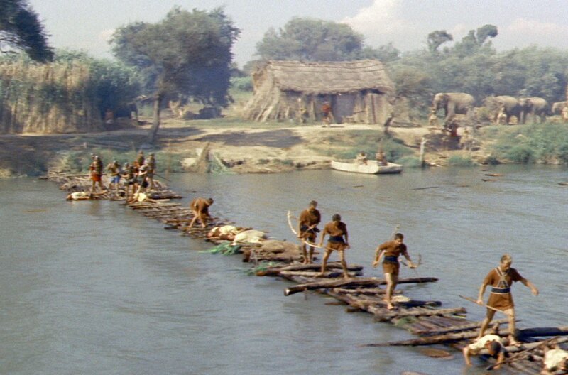 Die Holzkonstruktion, die Hannibals Heer nutzt, um den Fluss zu überqueren, wird nach einem Angriff der Römer zerstört. – Bild: ARTE /​ © 1960 Warner Bros. Inc. /​ © 1960 Warner Bros. Inc.
