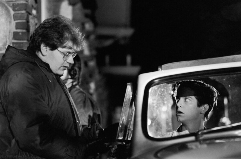 Regisseur Robert Zemeckis (li.) spricht mit Michael J. Fox (re.) in der Rolle des Marty McFly am Set von „Zurück in die Zukunft“. – Bild: Alamy /​ © Alamy