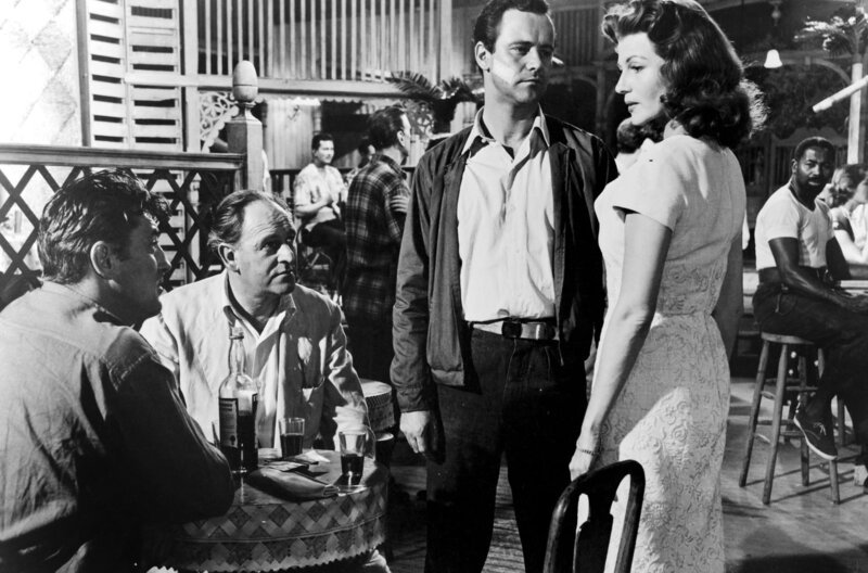 Tony (Jack Lemmon, 3.v.l.) stellt Irena (Rita Hayworth) in Anwesenheit von Dr. Sam Blake (Bernard Lee, 2.v.l.) und Felix (Robert Mitchum, li.) zur Rede. – Bild: arte
