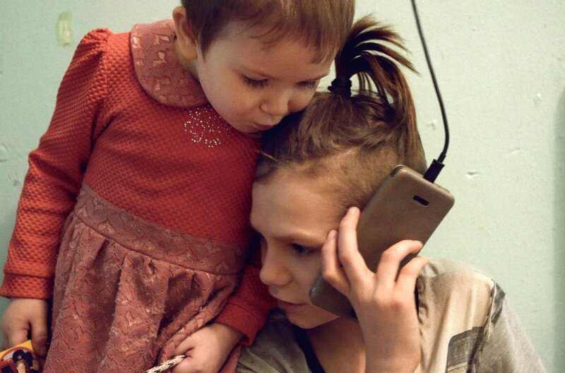Kolya und seine kleine Schwester Kristina telefonieren mit ihrer Mutter. – Bild: Simon Lereng Wilmont/​Final Cut for Real /​ © Simon Lereng Wilmont/​Final Cut for Real