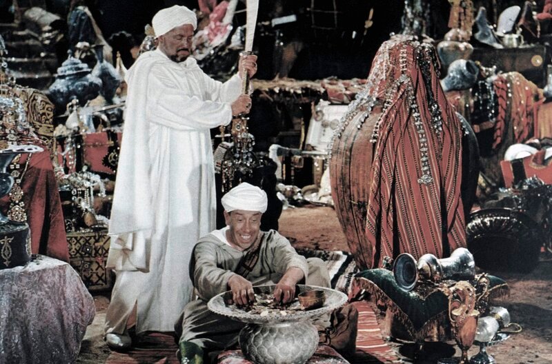 Cassim (Henri Vilbert, links) gönnt seinem einstigen Diener Ali Baba (Fernandel) den plötzlichen Reichtum nicht. – Bild: MDR/​Studiocanal
