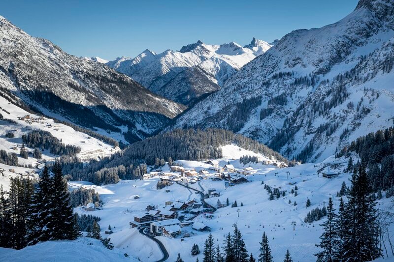 Winterlandschaft mit schneebedeckten Bergen und Bäumen im Bregenzerwald und dem kleinen Dorf Warth in Vorarlberg, Österreich. – Bild: Getty Images /​ www.michaelkemter.com /​ Kemter /​ E+ /​ Michael Kemter