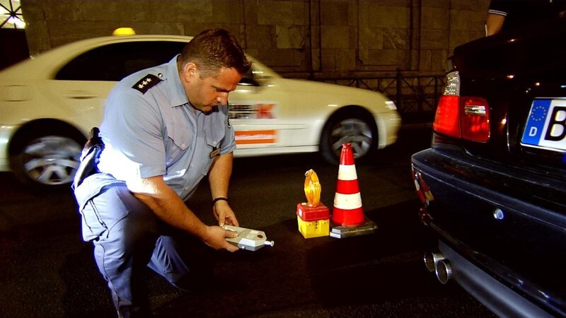 Der Beamte kontolliert ein Auto. – Bild: RTL Der Beamte kontolliert ein Auto. – Bild: RTL