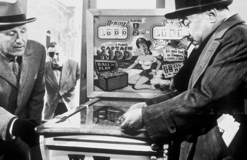 Vor dem Kommissar (Francis Blanche, re.) gibt sich der Opferstockdieb Georges Lachaunaye (Bourvil, li.) als Spielautomatenhersteller aus, um sein vieles Kleingeld zu erklären. – Bild: arte