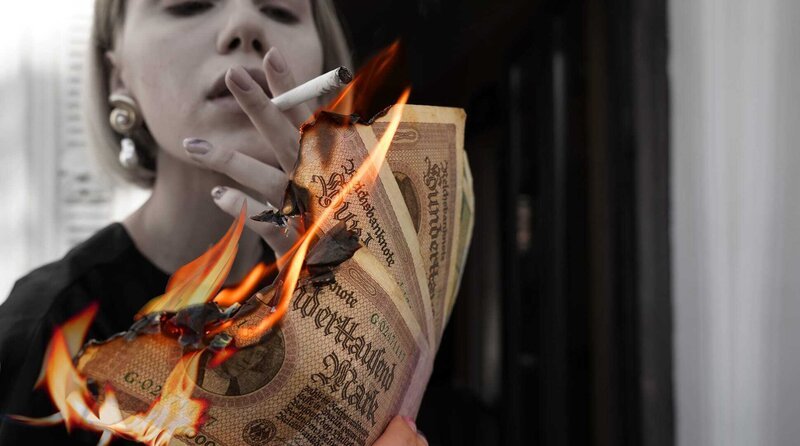 Ein Streichholz hätte womöglich mehr gekostet: mit Inflationsgeld eine Zigarette anzünden. – Bild: ZDF und Radio Bremen. Ein Streichholz hätte womöglich mehr gekostet: mit Inflationsgeld eine Zigarette anzünden. – Bild: ZDF und Radio Bremen.