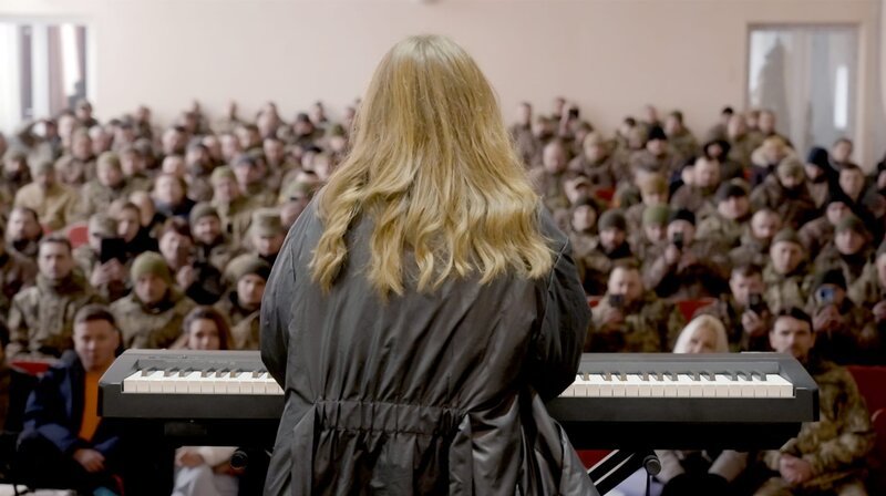 Die Musikerin Vlada Butschko spielt ein Konzert für Soldaten, die bald wieder an die Front müssen. – Bild: WDR/​Robin Drescher