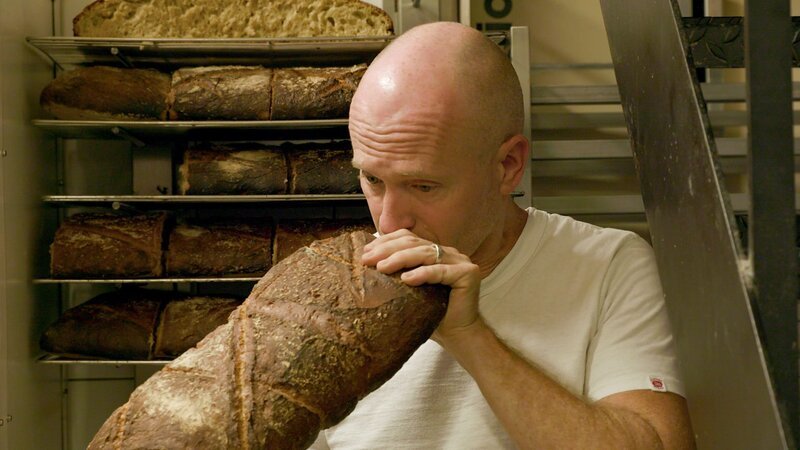 Christoph Vasseur riecht an einem frisch gebackenen „Pain des Amis“. – Bild: 3sat Christoph Vasseur riecht an einem frisch gebackenen „Pain des Amis“. – Bild: 3sat