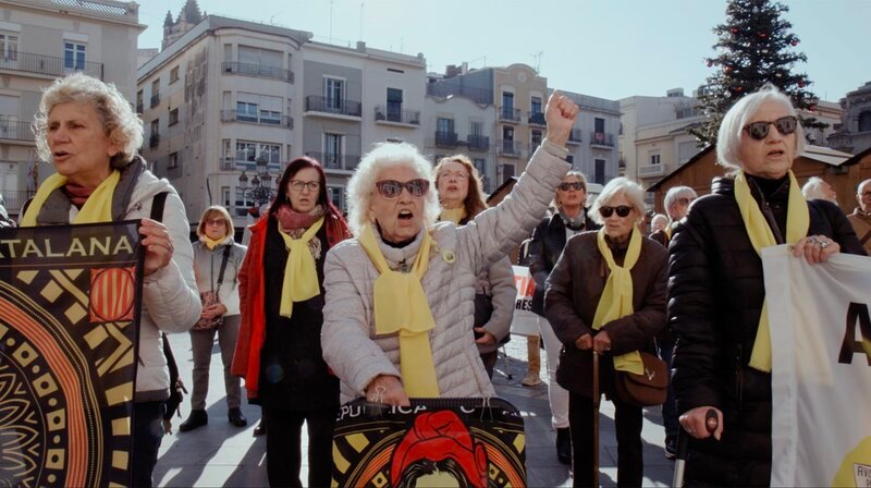 Die Katalanin Maria Avens (Mitte) und ihre Mitstreiterinnen demonstrieren seit dem verbotenen Referendum jeden Tag in der Stadt Reus südwestlich von Barcelona für die katalanische Unabhängigkeit. Die gelben Schals sind Symbole dafür. – Bild: WDR/​The Big Story