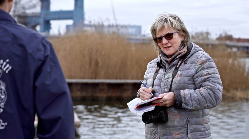 Für ihre Interviewtermine muss die Lokalreporterin weite Strecken fahren: Cornelia Meerkatz berichtet aus dem Landkreis Vorpommern-Greifswald für die Ostsee-Zeitung. Meerkatz ist zu Gast beim Ruderverein in Wolgast und interviewt einen Nachwuchssportler. – Bild: BR/​NDR/​Laura Borchardt/​Laura Borchardt