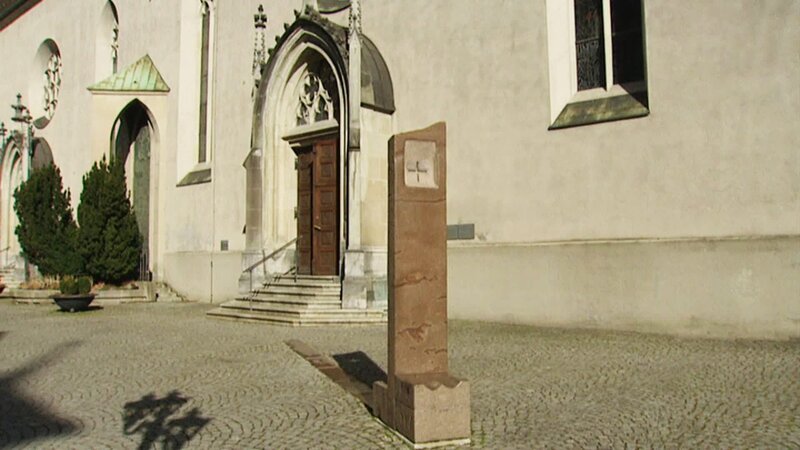 Das Denkmal, in Form eines großen Betstuhls, befindet sich auf dem Feldkirchner Domplatz. – Bild: ORF/​ORF-V