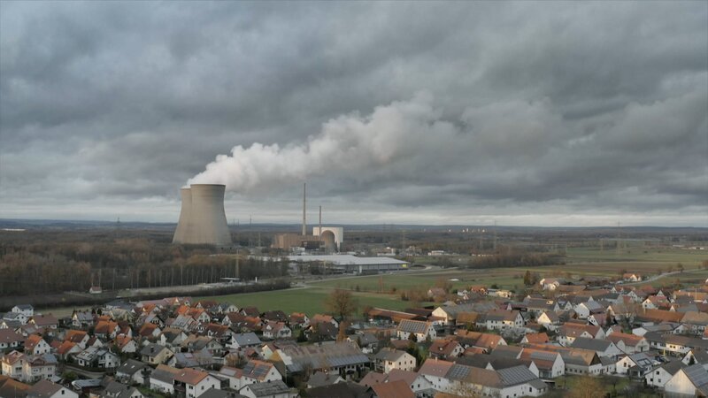 Die Stadt Gundremmingen: im Hintergrund die dampfenden Kühltürme des Atomkraftwerks. – Bild: Felix Landbeck /​ BR, Gruppe 5 Filmproduktion GmbH /​ BR/​Gruppe 5 Filmproduktion GmbH/​Felix Landbeck