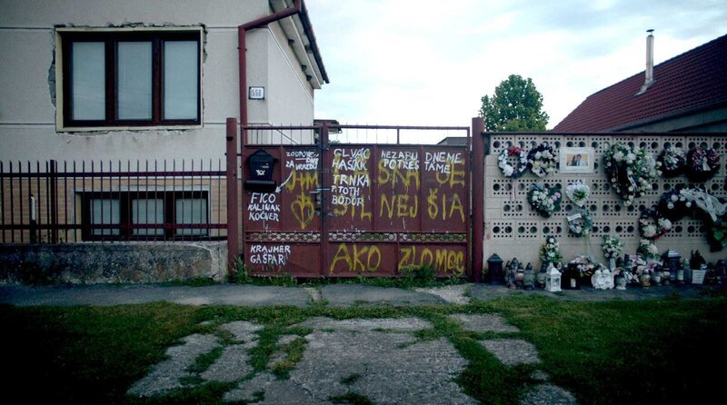 Tor des Hauses von Ján Kuciak und seiner Freundin Martina Kušnírová, die beide hier ermordet wurden. Die Graffitis und Bilder wurden dort nach der Tat von Freunden und Unterstützern platziert. – Bild: WDR/​Final Cut for Real/​Anna Smoroňová