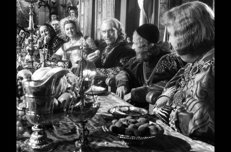 Zur feierlichen Rückkehr von Christopher Columbus (Fredric March, Mi.) sitzt dieser gemeinsam mit der Königin (Florence Eldridge, h.l.) und Adelsherr Francisco (Francis L. Sullivan, v.r.) am Festtisch. – Bild: Koch Media /​ Zur feierlichen Rückkehr von Christopher Columbus (Fredric March, Mi.) sitzt dieser gemeinsam mit der Königin (Florence Eldridge, h.l.) und Adelsherr Francisco (Francis L. Sullivan, v.r.) am Festtisch.
