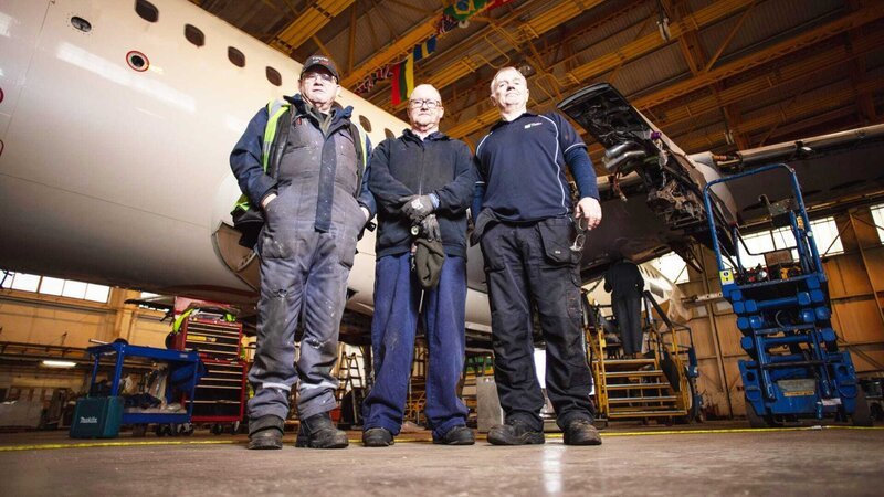 Contributors in Hangar with plane in backgroun – Bild: TCB