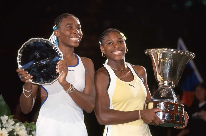 Siegerin Serena Williams (re.) und ihre Schwester und Zweitplatzierte Venus (li.) posieren mit ihren Trophäen nach dem Damenfinale des Compaq Grand Slam Cup 1991 in München. – Bild: Getty Images/​Professional Sport /​ Siegerin Serena Williams (re.) und ihre Schwester und Zweitplatzierte Venus (li.) posieren mit ihren Trophäen nach dem Damenfinale des Compaq Grand Slam Cup 1991 in München.