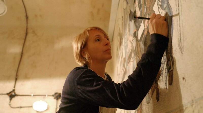 Restauratorin Céline Antoine versucht die Wandmalereien französischer Soldaten an den Bunkerwänden vor dem Verfall zu retten. – Bild: SWR/​Markus Winterbauer